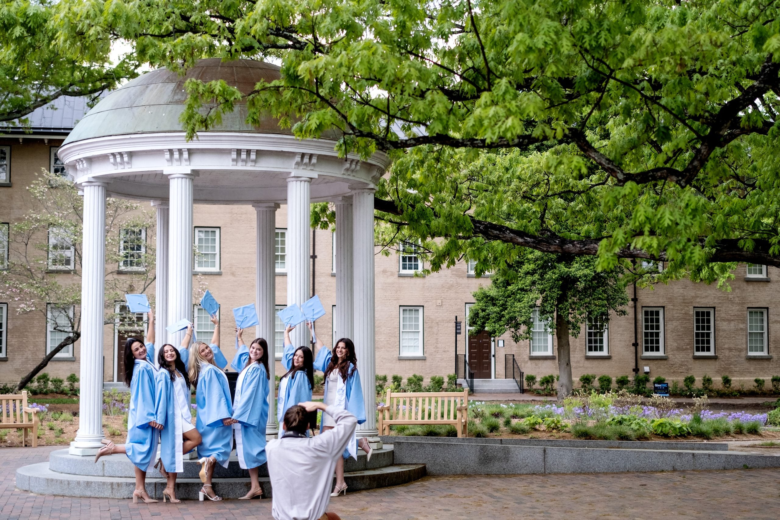 Graduates pose for photos by the Old Well