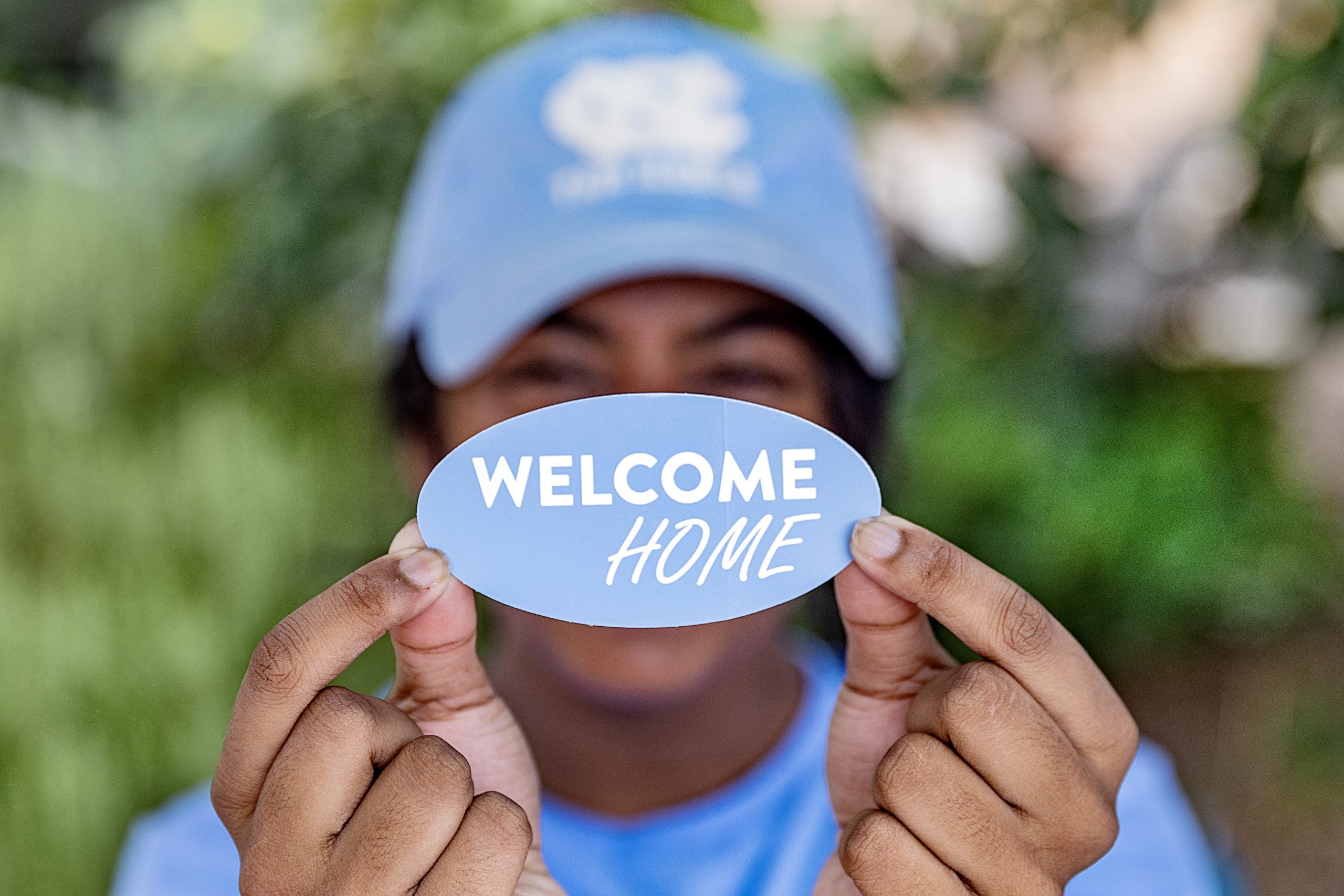 Student at UNC-Chapel Hill holding up a sticker that says 