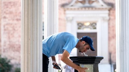 Student sipping from the Old Well on the first day of classes at UNC-Chapel Hill.