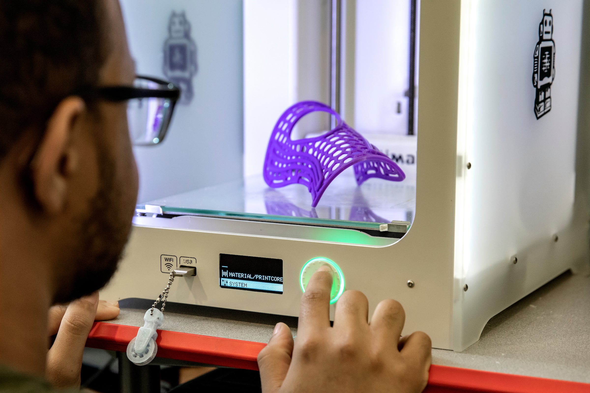 A person uses a 3D printer.