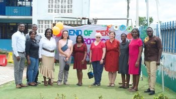 Teachers from North Carolina stand in front of a sign in Ghana celebrating the end of the school year.
