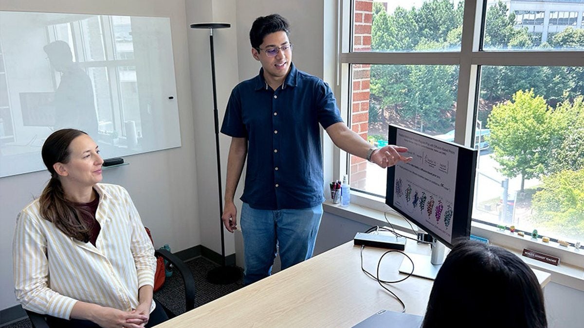 Amartya Banerjee discusses his artificial intelligence research with two co-authors.