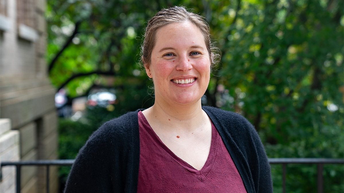 Emily Arnsberg posing for portrait on sunny day on the front steps of Bynum Hall on the campus of UNC-Chapel Hill.
