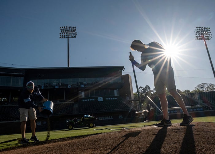 Anderson tamps the clay around the pitcher's mound. 