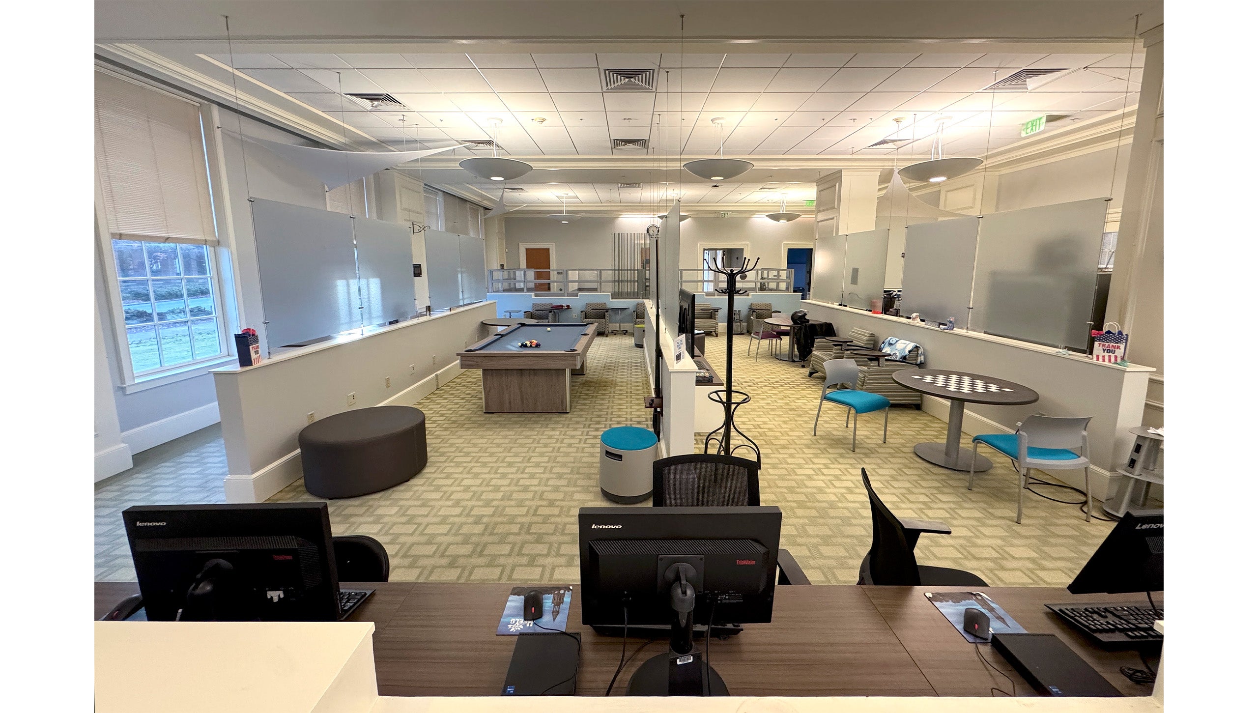 Inside of the UNC-Chapel Hill Military and Veteran Student Success Center featuring desks, tables, computers and a pool table.