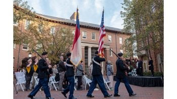 UNC-Chapel Hill ROTC members marching and carrying the American and state of North Carolina flags at the grand opening of the Military and Veteran Student Success Center.