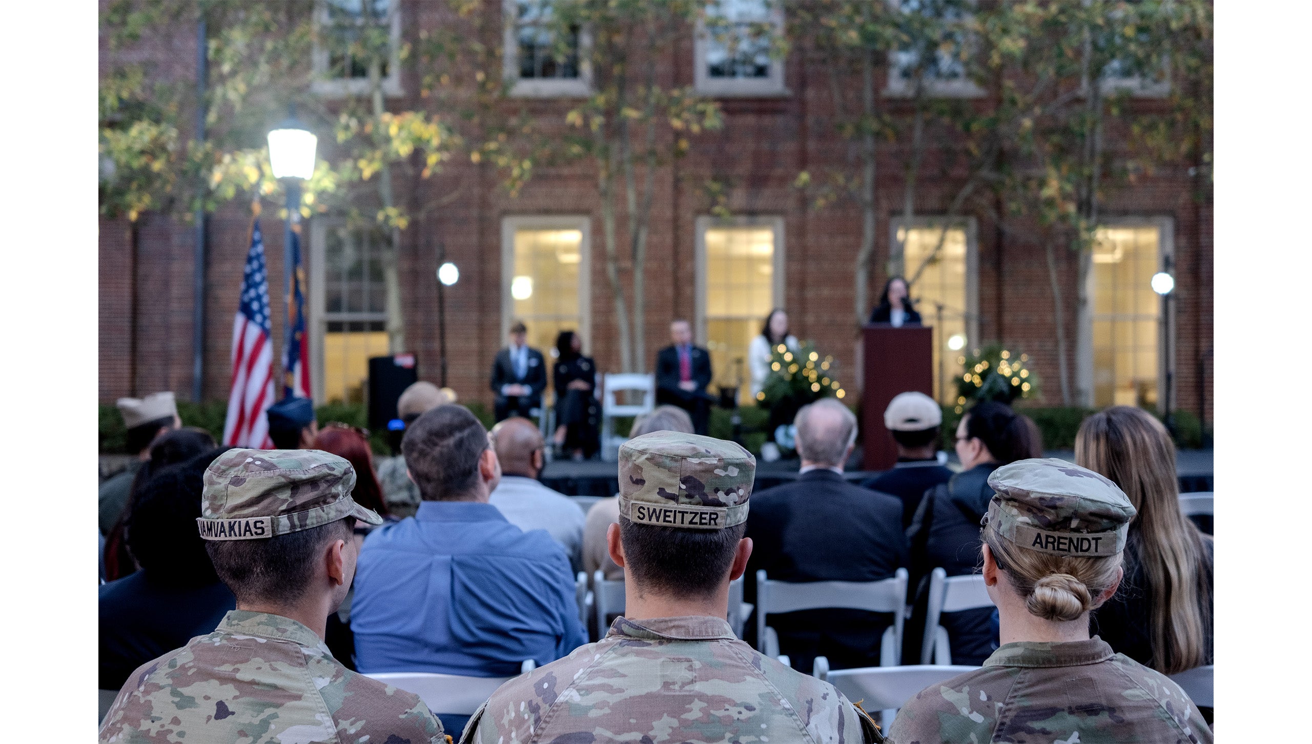 Rows of event attendees, including three ROTC members, sitting and listening to remarks at the grand opening of the Military and Veteran Student Success Center at UNC-Chapel Hill.