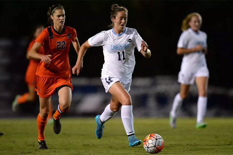 Darcy McFarlane dribbling the ball during a UNC-Syracuse women's soccer game.