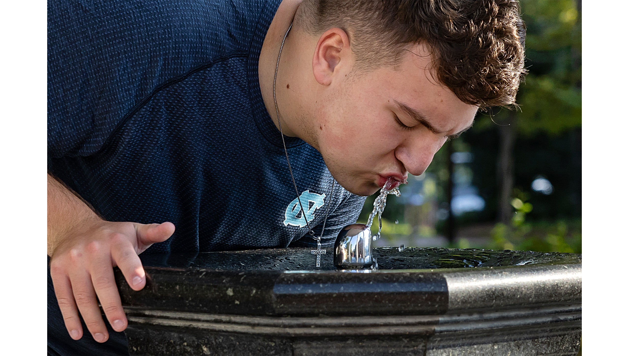 Close-up image of a UNC-Chapel Hill student sipping from the Old Well.