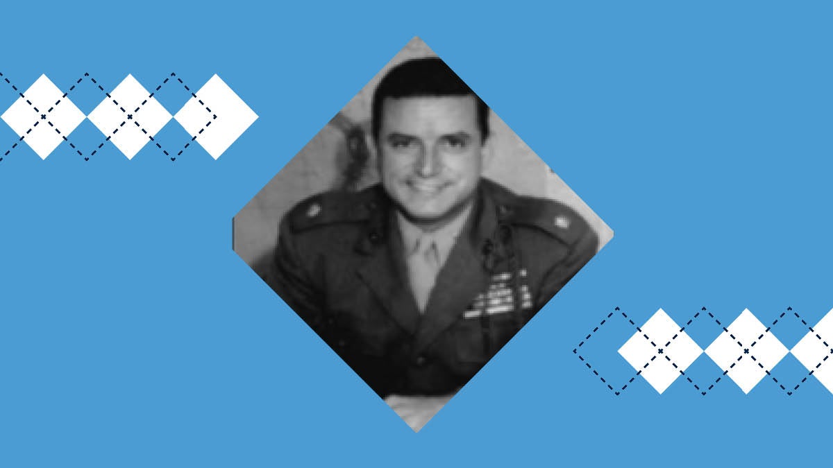 Maj. Everett "Bud" Hampton smiles for a photo while sitting at a table and wearing his Marine Corps uniform.