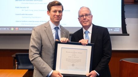 Chancellor Lee H. Roberts and James Lelouidis posing for a photo while jointly holding Leloudis’ Jefferson Award plaque.