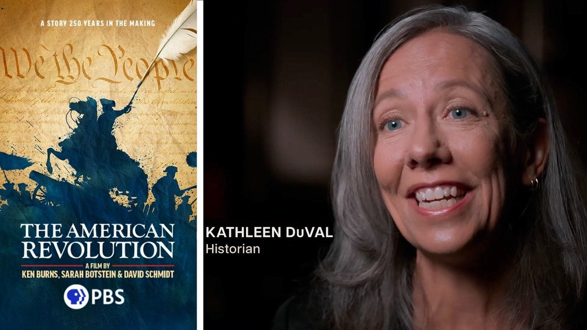 Kathleen DuVal next to a poster of the PBS American Revolution series.