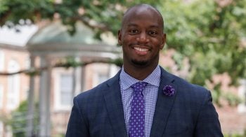 Marcus Ginyard poses for a photo in front of the Old Well on the campus of U.N.C. at Chapel Hill.