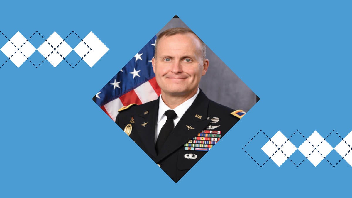 Col. Richard Martin poses for a photo in his military uniform next to an American flag.