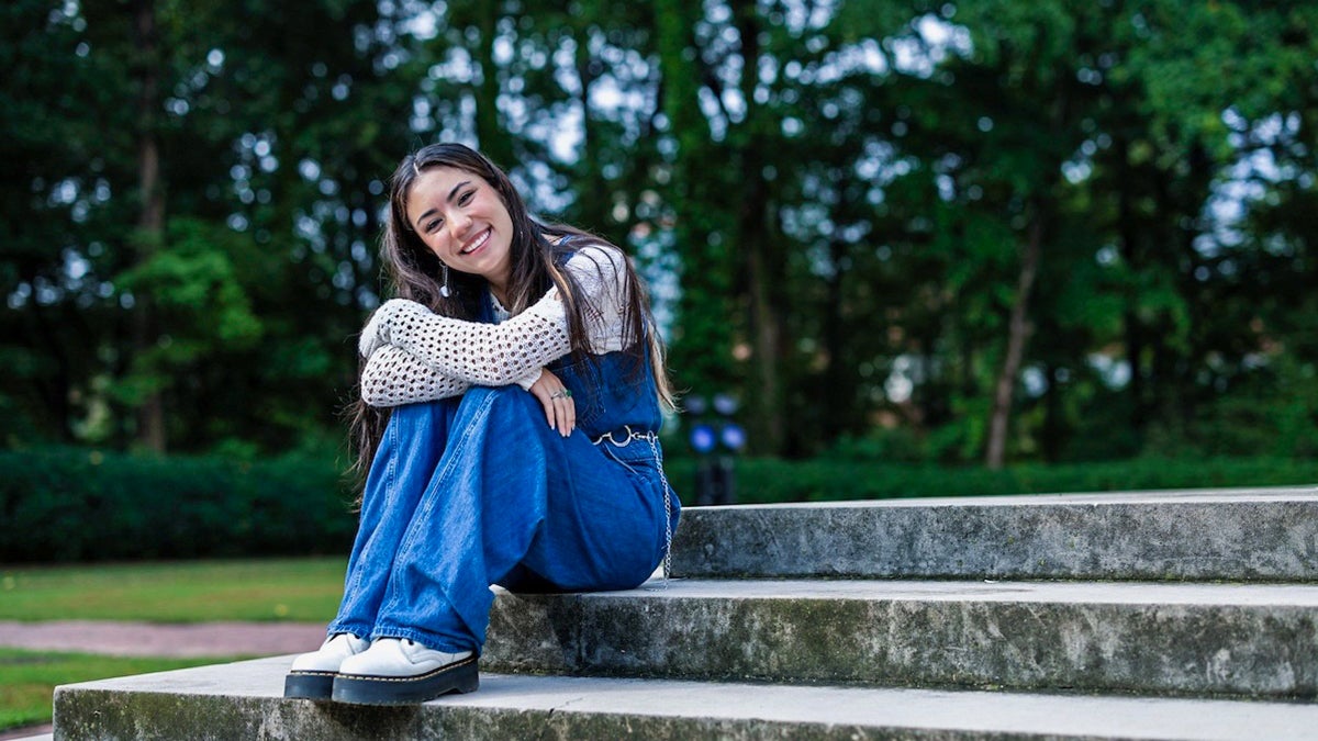 Mel Dalili posing for a photo at the foot of the steps of the U.N.C. bell tower.