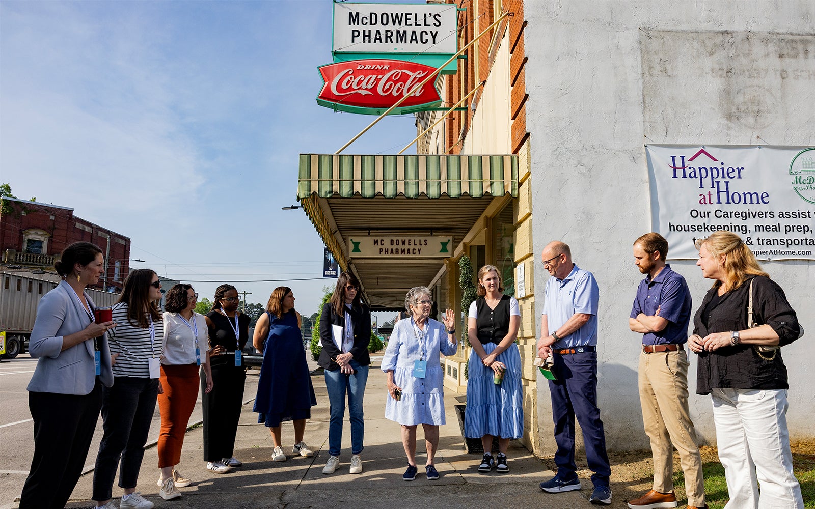Members of the Tar Heel Bus Tour speak with the owners of McDowell's Pharmacy in Scotland Neck, North Carolina.