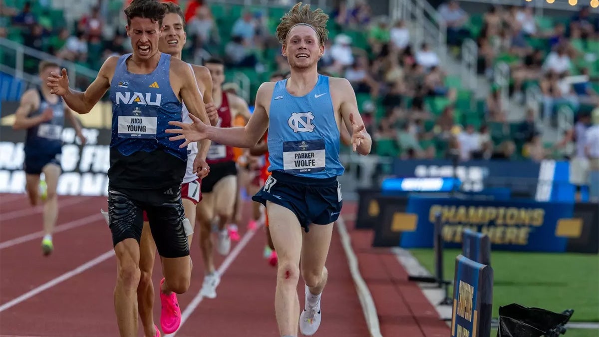 Parker Wolfe crossing the finish line on a track in the 5000m championship.