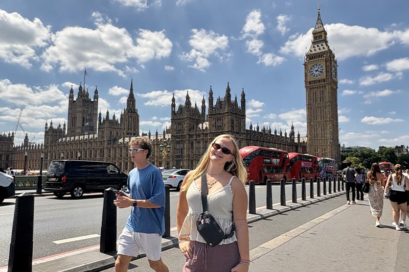 Kinlee Reece posing for photo on London sidewalk with the Big Ben clock seen in the background.