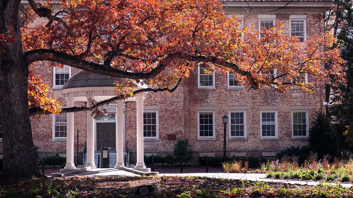 Exterior image of the Old Well in the fall, partially obscured by a tree branch.