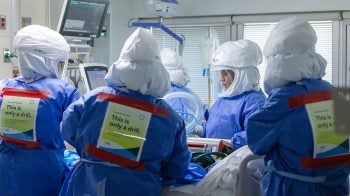 Group of individuals wearing scrubs and hazmat face shields.