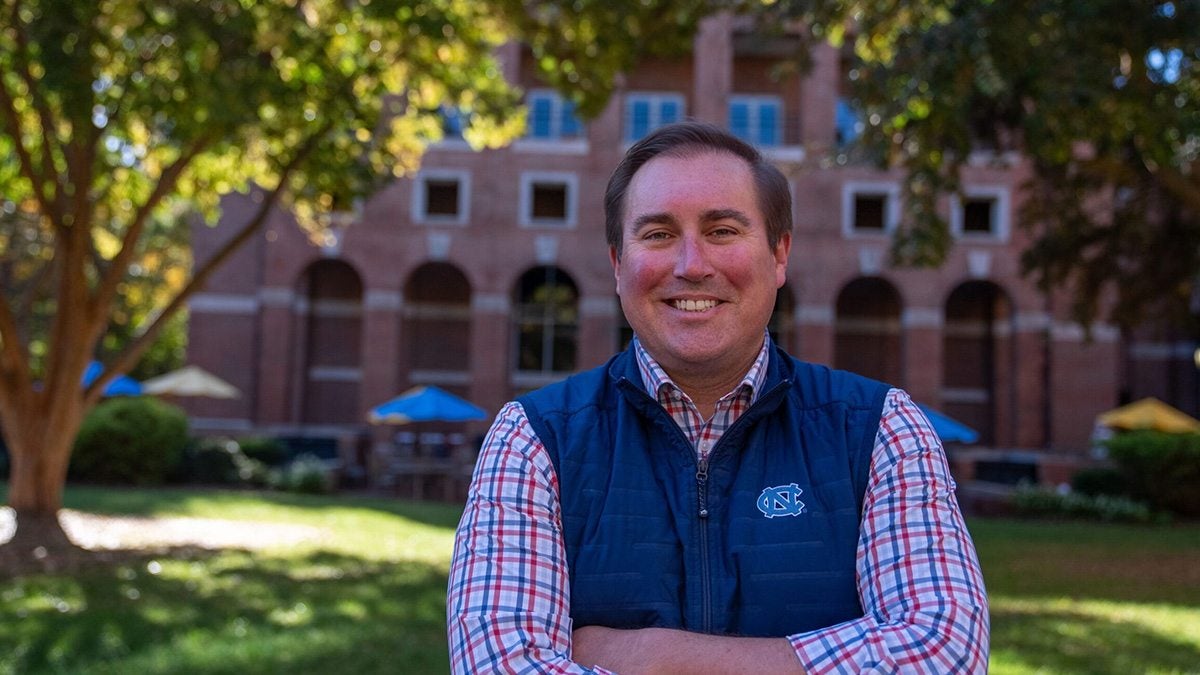 Michael Stutts poses for a photo in front of a U.N.C. building.