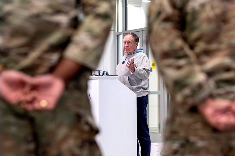 Carolina football coach Bill Belichick speaks during a press conference about the "Honoring Our Military" wall in the Kenan Football Center. In this photo, he is framed between two Army R.O.T.C. students.