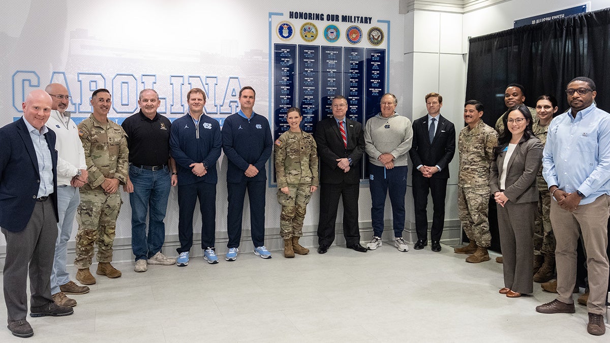 A group of University officials, including football coach Bill Belichick, Chancellor Lee H. Roberts, Dean of Students Desireé Rieckenberg, director of the Military Veteran and Student Success Center Rob Palermo and incoming athletic director Steve Newmark pose with the new 