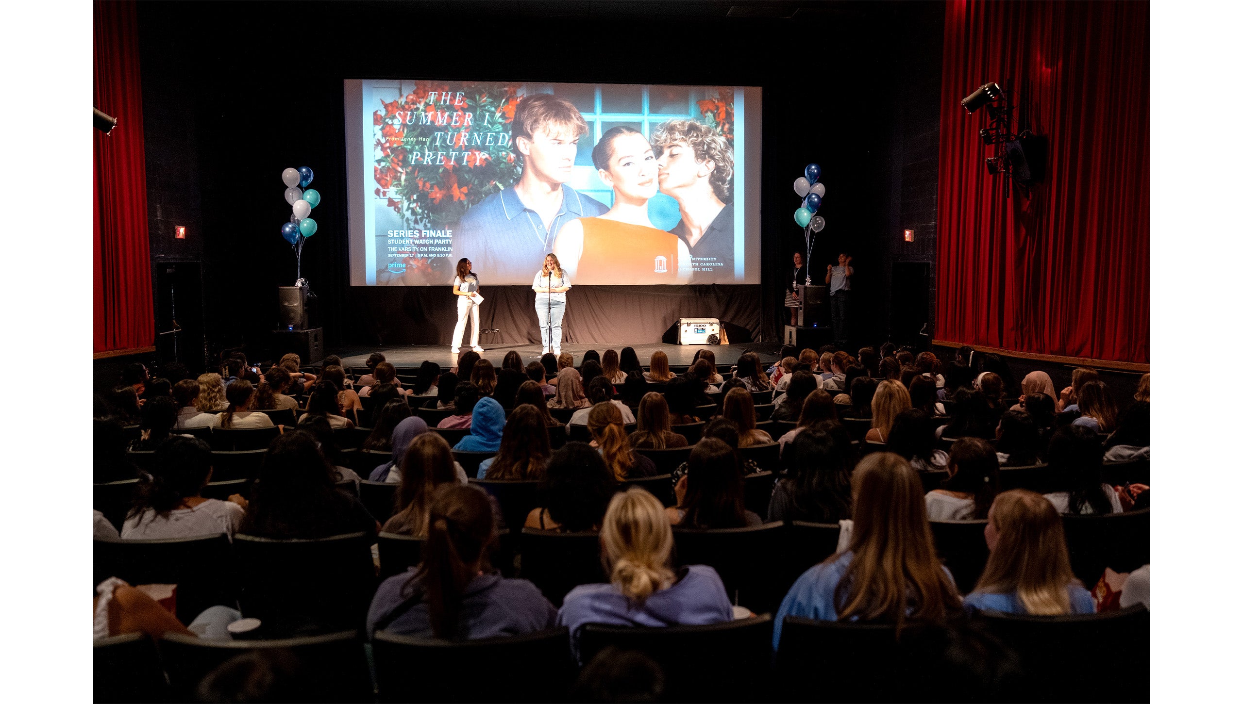Two people speaking on stage before the watch party for “The Summer I Turned Pretty” at the Varsity Theatre.
