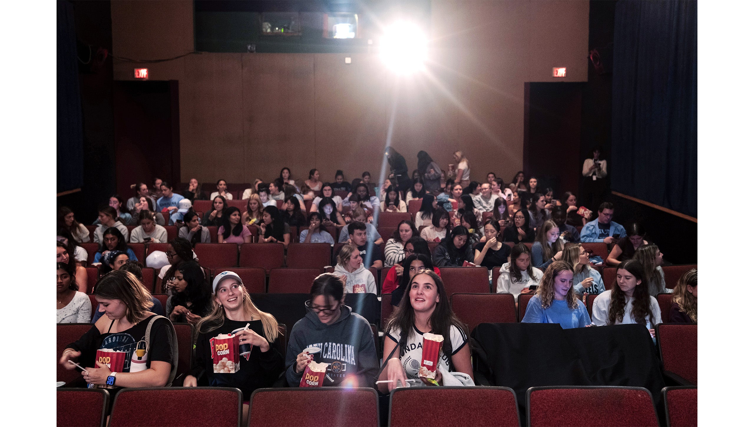 Rows of students, some with popcorn, in the Varsity Theatre at “The Summer I Turned Pretty” watch party.