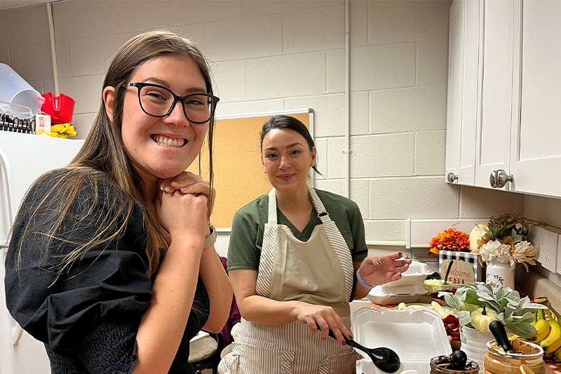 On the right, Jessica Hill cooks waffles for her friends, while a friend of hers smiles on the left.