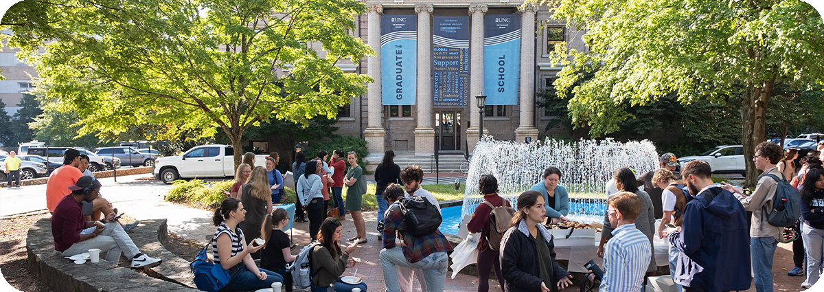 Group of UNC-Chapel Hill graduate students and faculty and staff gathered near the fountain outside of Bynum Hall during a get-together.