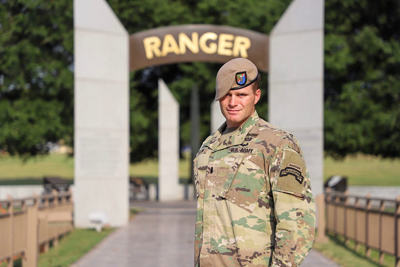 Jack Austin in his military uniform with a sign in the background which reads "Ranger."
