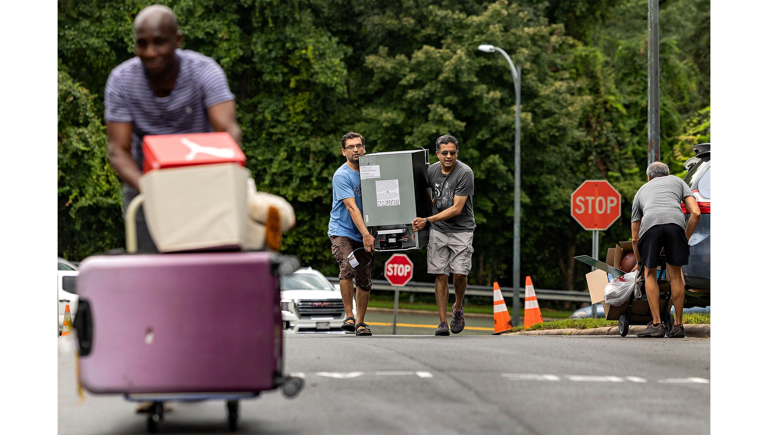 Two men carrying a refrigerator.