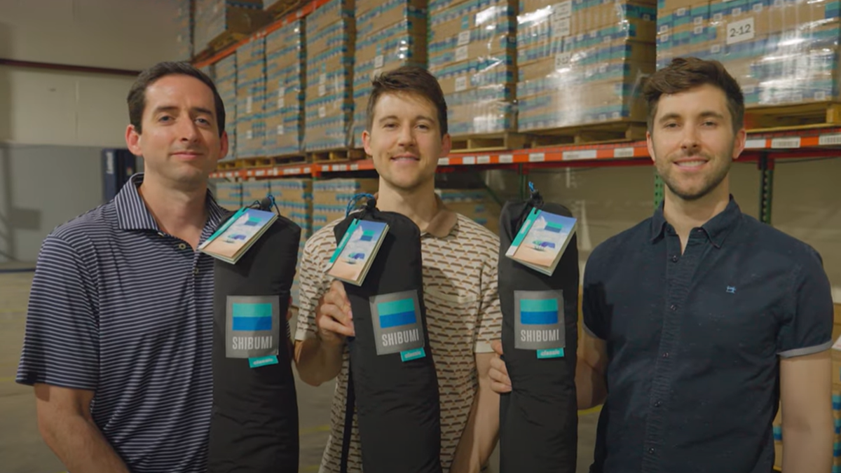 Three co-founders of Shibumi holding the product in its bag.